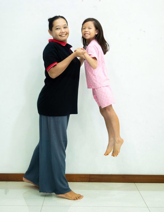 A Unistarr helper in uniform playing with a child at home