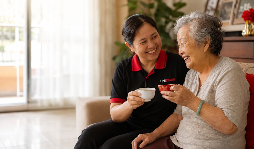A Unistarr helper in uniform sharing tea and a warm conversation with an elderly woman